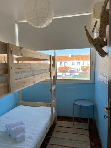 a bunk bed in a room with a window at Casa São Francisco in Porto Covo