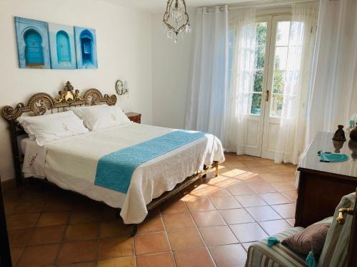 ein Schlafzimmer mit einem Bett mit einer blauen und weißen Decke in der Unterkunft Villa Provenzale in Sanremo