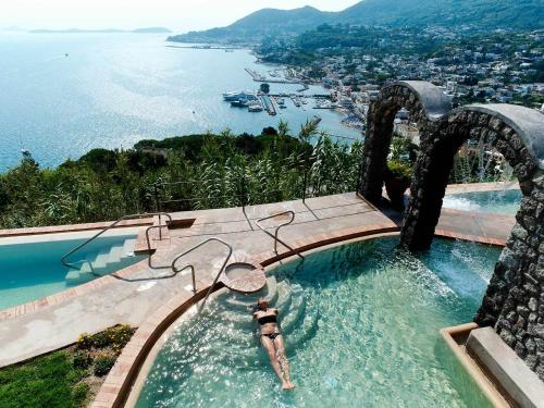 a water slide in a pool next to a body of water at San Montano Resort & Spa in Ischia