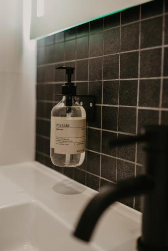 a bottle of soap on a wall next to a sink at Bed en Baguette in Burgh Haamstede