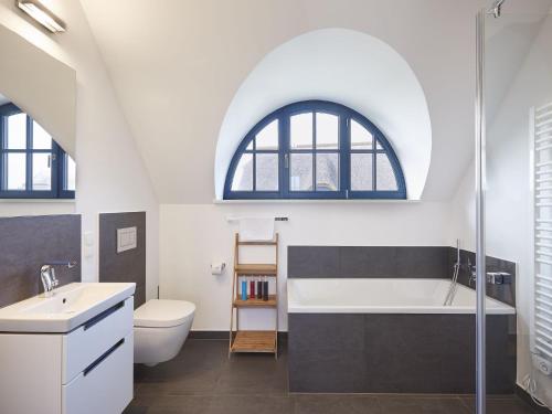 an attic bathroom with a sink and a bath tub at Reetland am Meer - Luxus Reetdachvilla mit 3 Schlafzimmern, Sauna und Kamin F12 in Dranske