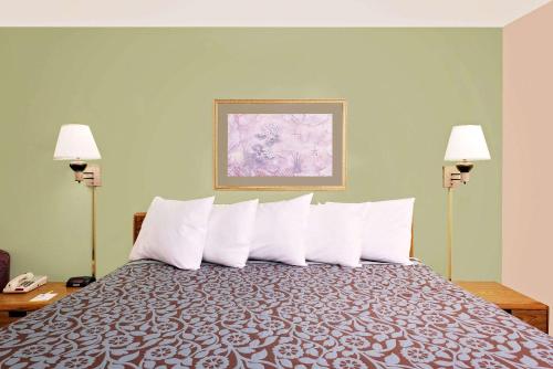 a hotel room with a bed with white pillows at Days Inn by Wyndham Cleveland TN in Cleveland