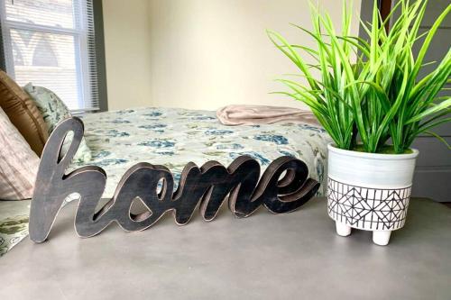a sign that says home next to a potted plant at 6BR Retreat-Great for Reunions and Getaways minutes from Niagara Falls in Niagara Falls