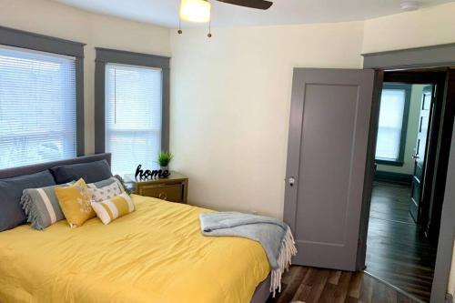 um quarto com uma cama grande com lençóis e almofadas amarelos em The Hennepin House- With Private Yard & Parking, Minutes From Falls & Casino by Niagara Hospitality em Niagara Falls