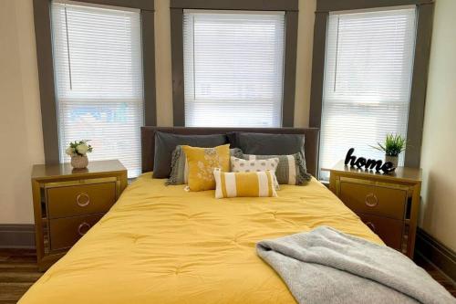 a bedroom with a large yellow bed with windows at 6BR Retreat-Great for Reunions and Getaways minutes from Niagara Falls in Niagara Falls