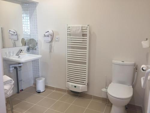 a white bathroom with a toilet and a sink at La Rose in Juliénas