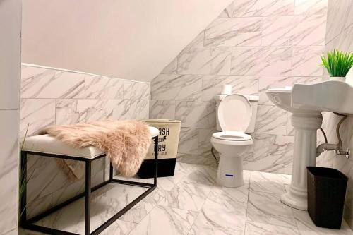 a bathroom with a sink and a toilet and a stool at 5BR Niagara Getaway Prime Location-Sleeps 10 in Niagara Falls
