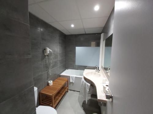 a bathroom with a sink and a toilet and a tub at Hôtel Eiffel Kensington in Paris