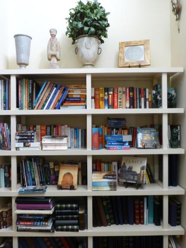 a white book shelf filled with books at Lakeside Bed & Breakfast in Perth