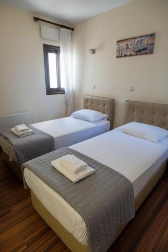 two beds in a hotel room with towels on them at Seafront Protaras Villas in Protaras