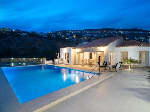a villa with a large swimming pool at night at Holiday Home Vista al Mar by Interhome in Benitachell