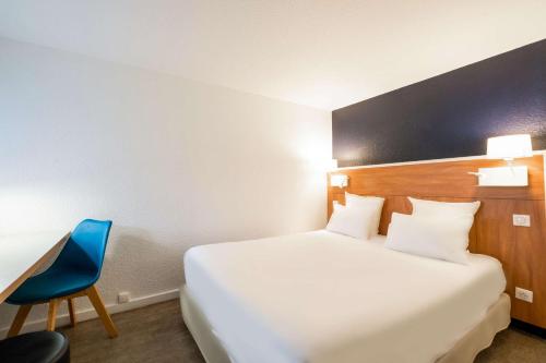 una camera d'albergo con letto e sedia blu di Comfort Hotel ORLY-RUNGIS a Rungis