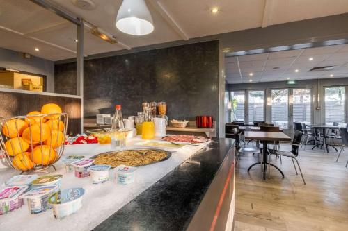 a kitchen with a counter with food on it at Comfort Hôtel RUNGIS-ORLY in Rungis