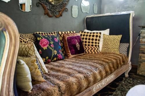a couch covered in pillows in a room at Honey Farm Country Get Away in Skeerpoort