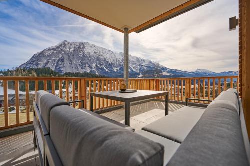 a balcony with a table and a view of a mountain at die Tauplitz Lodges - Adler Auszeit Lodge D6 by AA Holiday Homes in Tauplitz