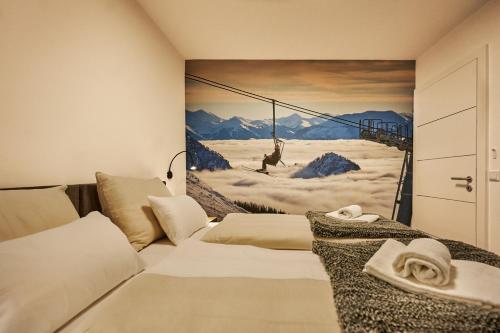 a bedroom with a painting of a man on a swing at die Tauplitz Lodges - Adler Auszeit Lodge D6 by AA Holiday Homes in Tauplitz