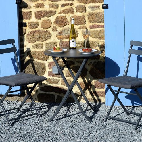 a table with a bottle of wine and two chairs at La Martinière in Saint-Aubin-Fosse-Louvain