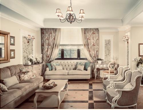 a living room with couches and a chandelier at PENSIUNEA DIMITRIOS Relaxare cu jacuzzi pe Valea Cernei in Băile Herculane