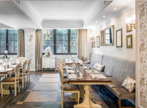 a restaurant with tables and chairs and a couch at PENSIUNEA DIMITRIOS Relaxare cu jacuzzi pe Valea Cernei in Băile Herculane