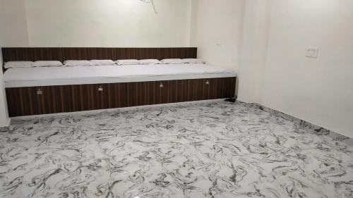 une chambre vide avec un lit et un matelas dans l'établissement Rajlakshmi Guest House, à Mathura