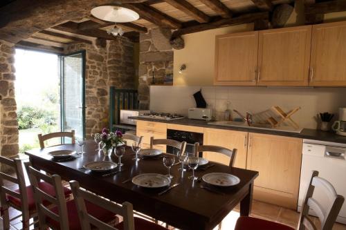 a kitchen with a table and chairs and a kitchen with a table and a table at Le Petit Courtoux in Saint-Germain-en-Coglès