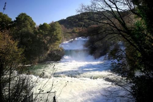 a river with a waterfall in a forest at Villa Susann in Šibenik
