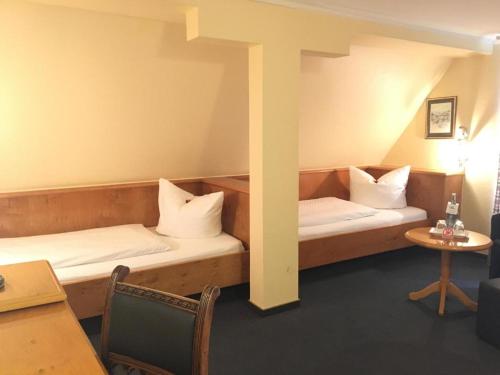 a room with two beds and a table at Stadthotel Waldhorn in Kirchheim unter Teck