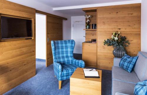 a living room with a couch and a chair at Das Aunhamer Suite & Spa Hotel in Bad Griesbach