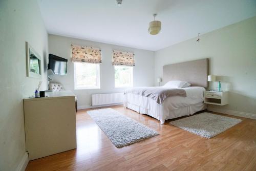 a bedroom with a bed and a wooden floor at Glenburn Galgorm Bed & Breakfast in Galgorm