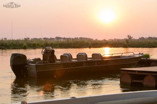 a boat sitting in the water at a dock at Sausage Tree Camp in Jeki