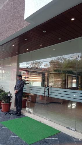 a man is standing in front of a building at Hotel DVIJ INN in Jaipur