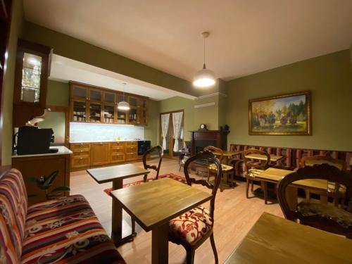 a living room with tables and chairs and a kitchen at Guesthouse Tershana in Peshkopi