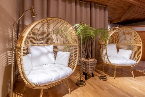 two wicker chairs in a room with plants at Hotel Montafoner Hof in Schruns-Tschagguns