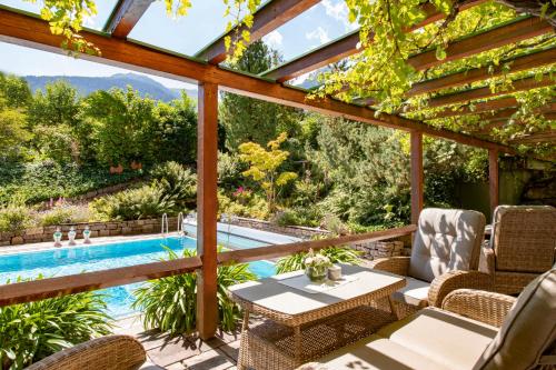 an outdoor patio with a pool and a pergola at Hotel Montafoner Hof in Schruns-Tschagguns
