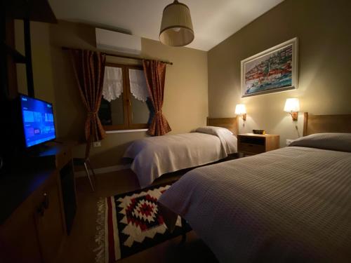 a hotel room with two beds and a flat screen tv at Guesthouse Tershana in Peshkopi