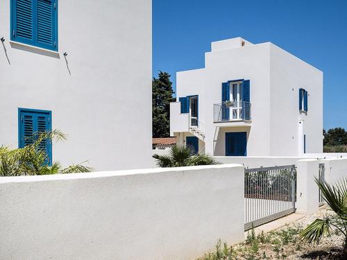 サン・ヴィート・ロ・カーポにあるLovely holiday home in San Vito lo Capo on the beachの青窓・柵のある白い家