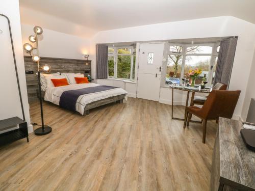 ein Schlafzimmer mit einem Bett, einem Schreibtisch und einem Tisch in der Unterkunft Hockerley Cottage in Highpeak Junction