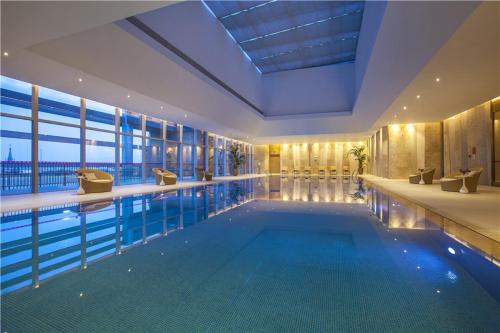 a swimming pool in a building with a large window at Crowne Plaza Zhangzhou, an IHG Hotel in Zhangzhou