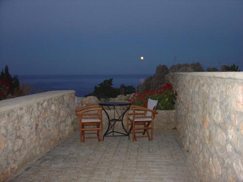 a table and chairs on a stone wall with the moon at Jhonathan in Amoopi