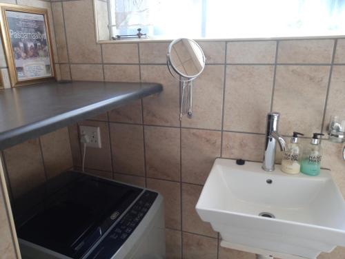 a small bathroom with a sink and a mirror at Grace in Pretoria