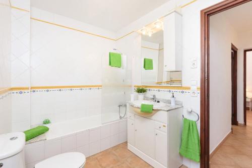a bathroom with a toilet and a sink and a tub at Villa Amapola by Villa Plus in Santo Tomás