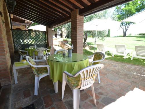 een patio met een tafel en stoelen en een parasol bij Belvilla by OYO Rosa Tea in Montaione
