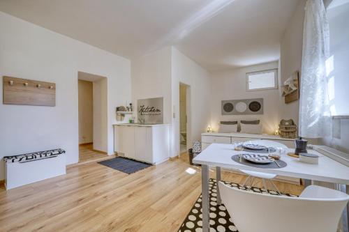 una cucina e un soggiorno con tavolo e sedie di Zentral gelegenes Apartment mit Garage und Garten a Caldaro