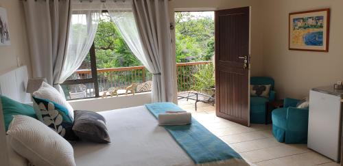 a living room with a bed and a large window at Sunbirds Bed & Breakfast in Southbroom
