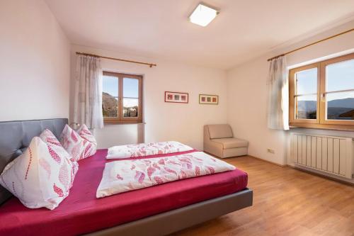 a bedroom with a bed and a chair in it at Stompferhof Erkerwohnung in Caldaro