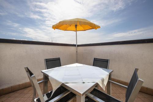 a table with a yellow umbrella on a balcony at Stompferhof Mansarde in Caldaro