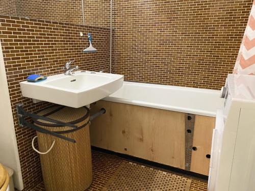 La salle de bains est pourvue d'un lavabo et d'une baignoire. dans l'établissement AS20085 - Studio spacieux avec piscine et parking commun, au Grau-du-Roi