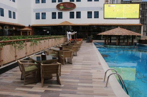 a row of tables and chairs next to a swimming pool at Elite Crystal Hotel in Manama