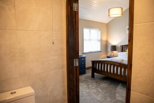 a bathroom with a bedroom with a bed and a window at Noel's Place in Doolin