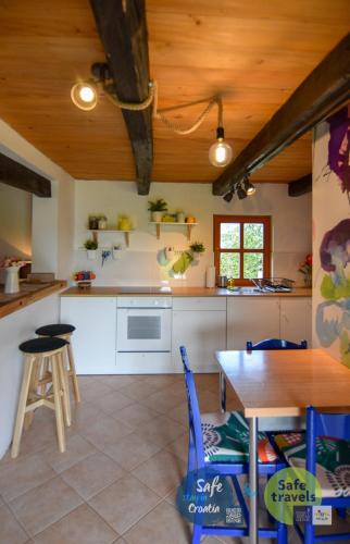 a kitchen with a wooden ceiling and a table at Kuća za odmor Lang in Karlovac
